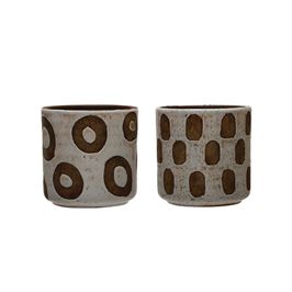 These Terra-cotta Planter w/ Shapes patterns in a White Distressed Finish Holds a 4" Pot. The two patterns are a donut shape pattern and a thumb print shape pattern.