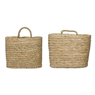 Hand-Woven Seagrass Wall Baskets w/ Handle are perfect to hang on your wall indoors or out or keep close to your feet. Add to your patio to keep your pool towels or add your special greenery for a bountiful feel. Baskets come in two sizes. Small: 14-1/2"L x 6-1/4"W x 13"H Large: 16"L x 8-3/4"W x 13-3/4"H Hangs or Sits